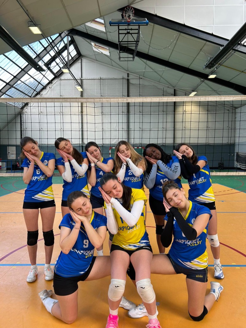 Jeunes joueuses en maillots bleu et jaune, la tête sur la main, posent en rang avec un ballon